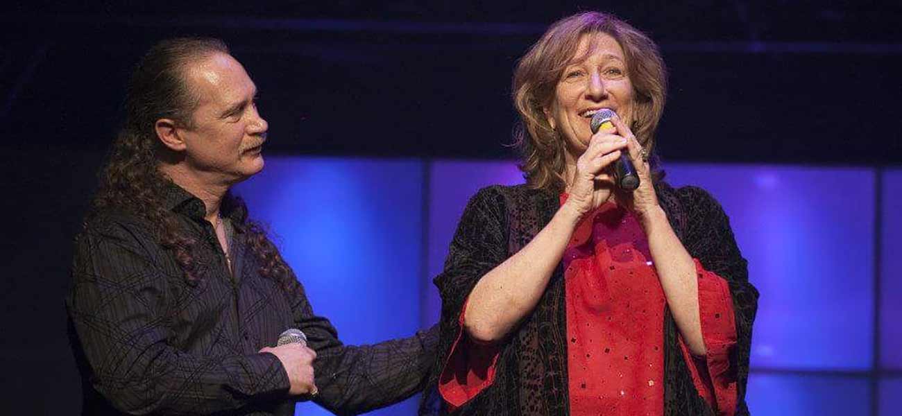Two performers on stage with blue and purple lighting