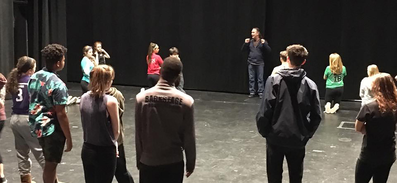 Instructor working with students on stage