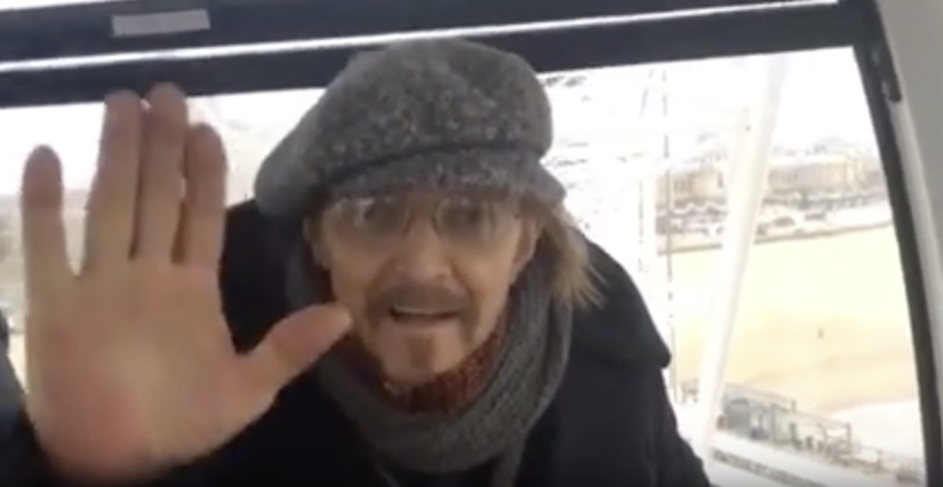 Ted Neeley wearing a hat showing his hand